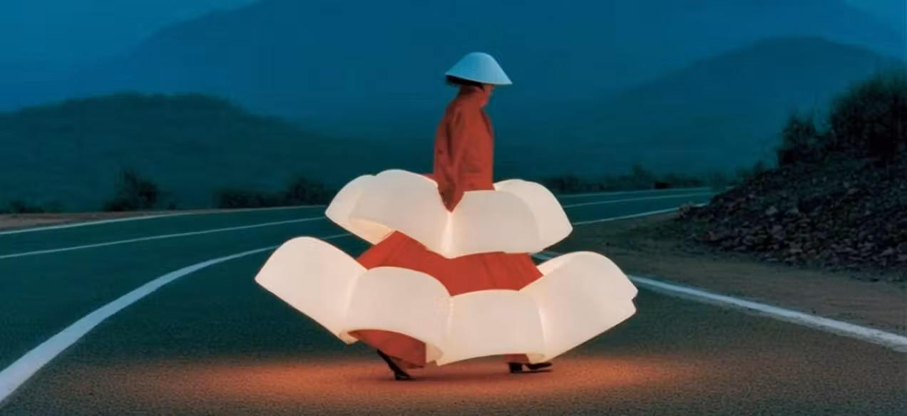Creative illustration: A woman in an orange top and a sculptural white skirt on an empty road