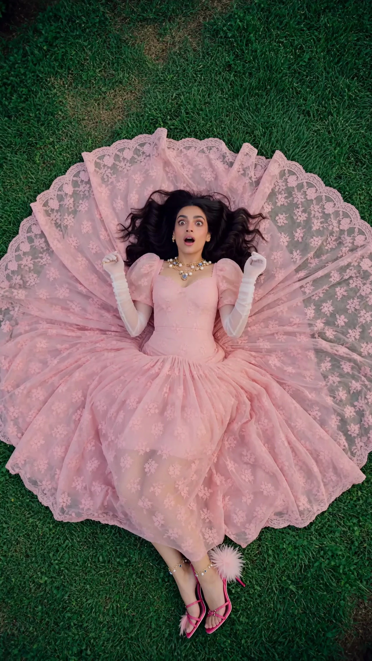 A woman wearing a pink dress in a garden