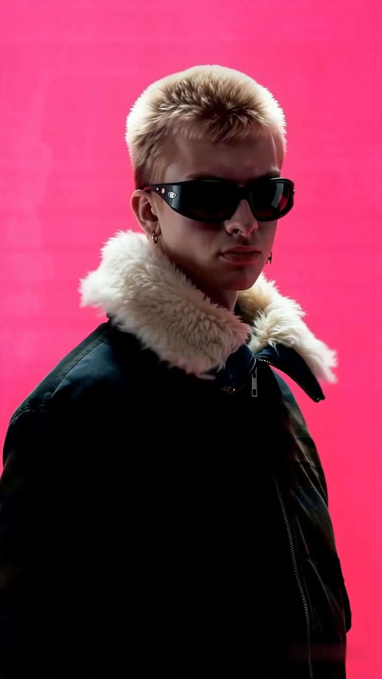 Kling 4 Beispiel: Eine Person mit Sonnenbrille und schwarzer Jacke vor leuchtend rosa Hintergrund