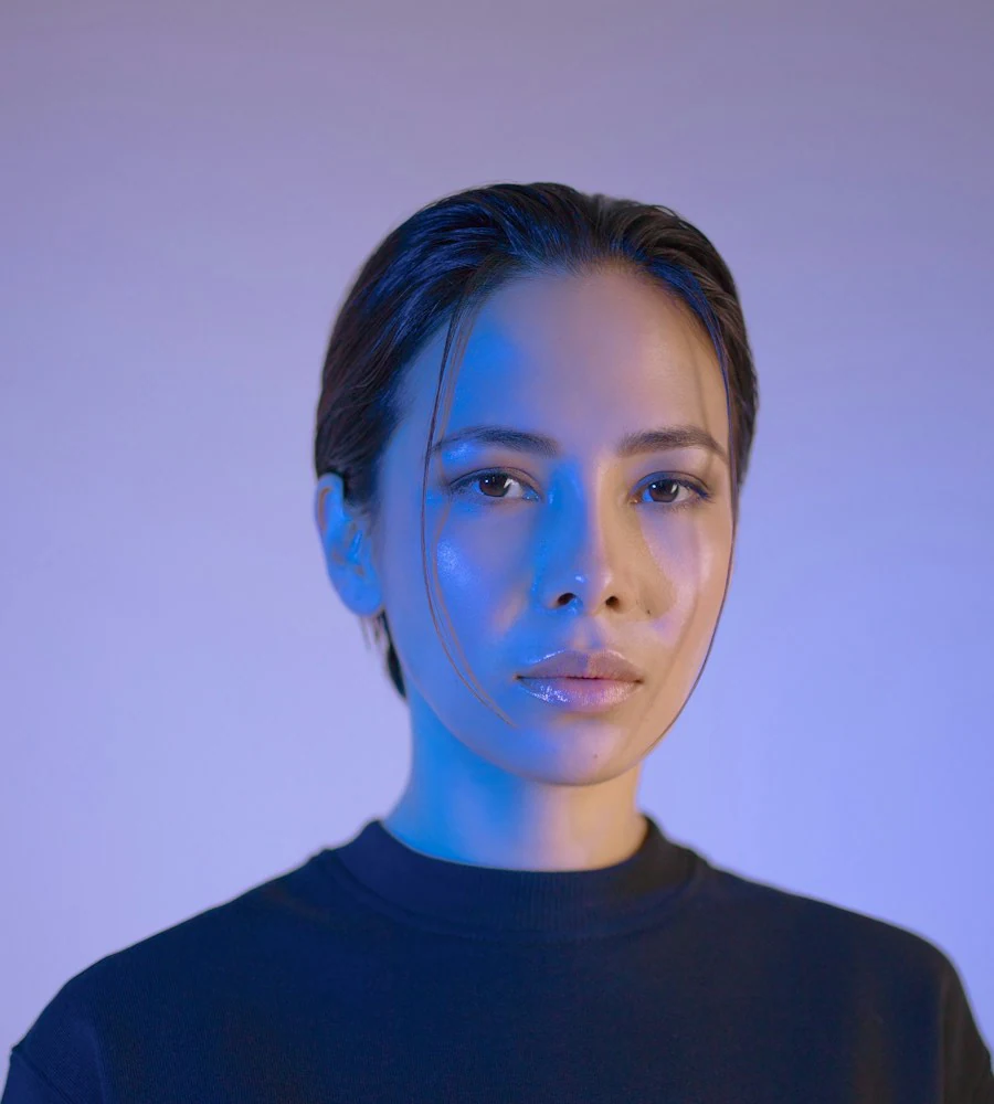 Creative illustration: A woman's portrait lit with blue and violet light