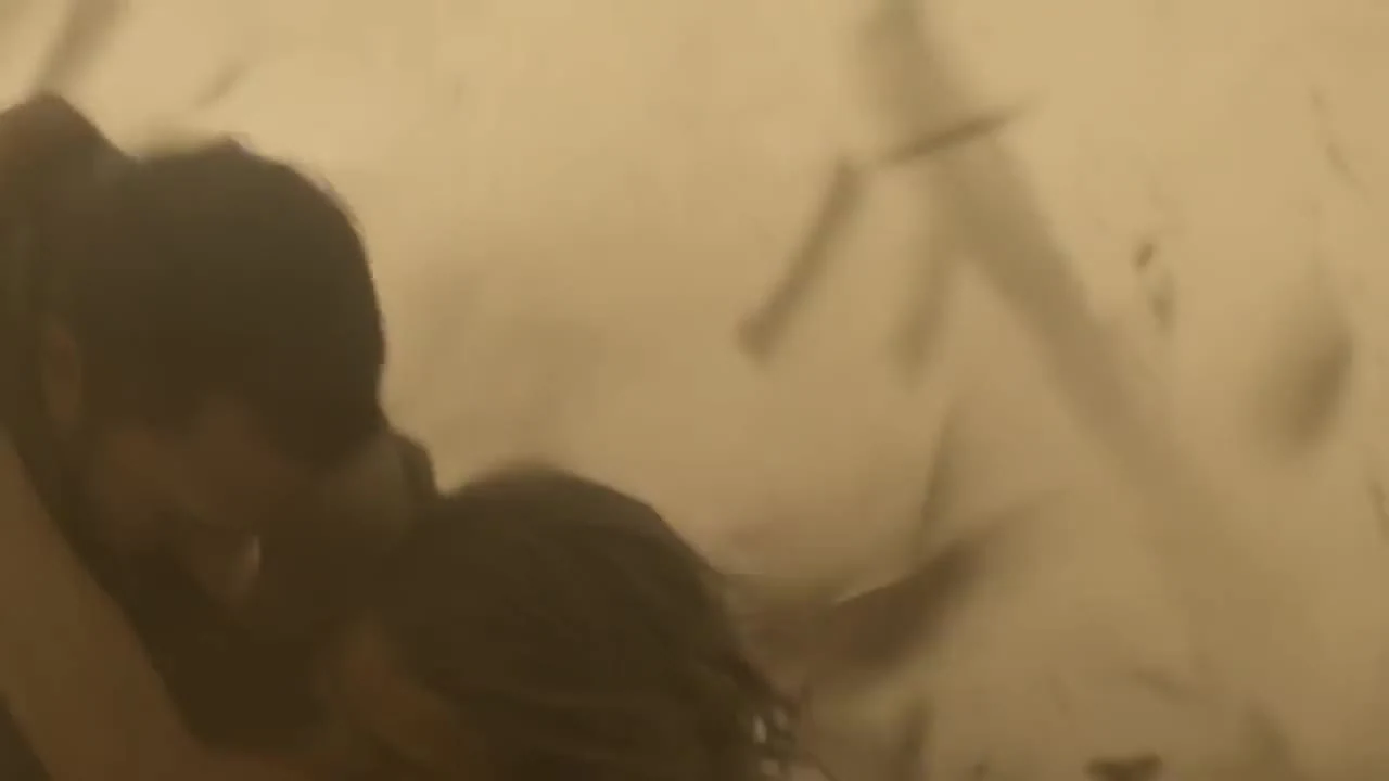 A figure moving through a dusty, golden-lit scene