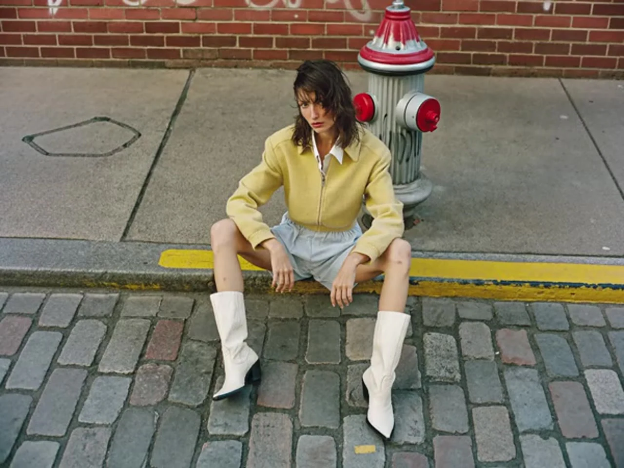 Creative illustration: A woman sitting on a curb beside a red fire hydrant